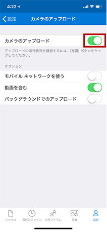 このスクリーンショットは、iPhoneの「カメラアップロード」機能が有効になっている画面です。オプションには、「モバイルネットワークを使用」（オフ）、「ビデオを含む」（オン）、および「バックグラウンドでのアップロード」（オフ）が含まれています。
