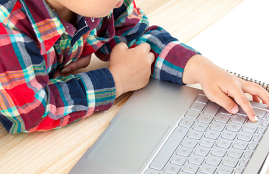 ノート PC を操作する子どもの手元