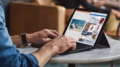 カフェでノート PC を操作する男性