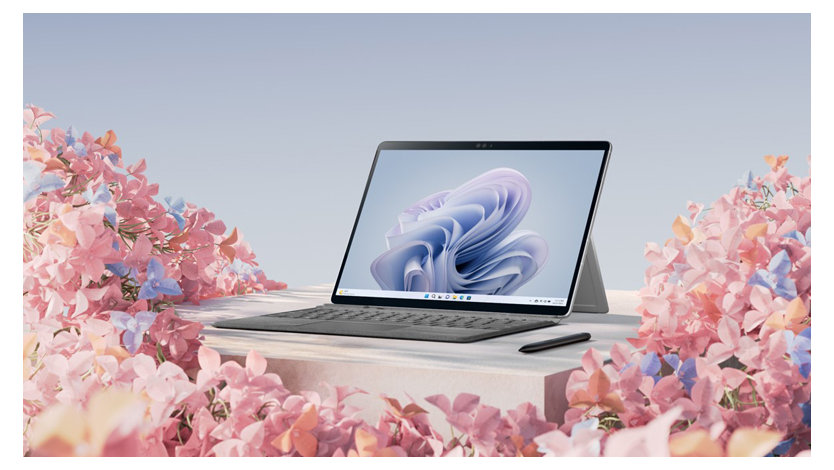 ピンクと紫の花に囲まれた Surface 9 Pro