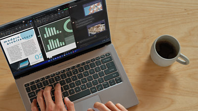 コーヒーカップと一緒にラップトップのキーボードに人間の手