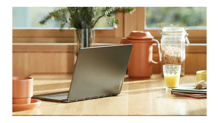 明るい窓際のテーブルに置かれたノート PC