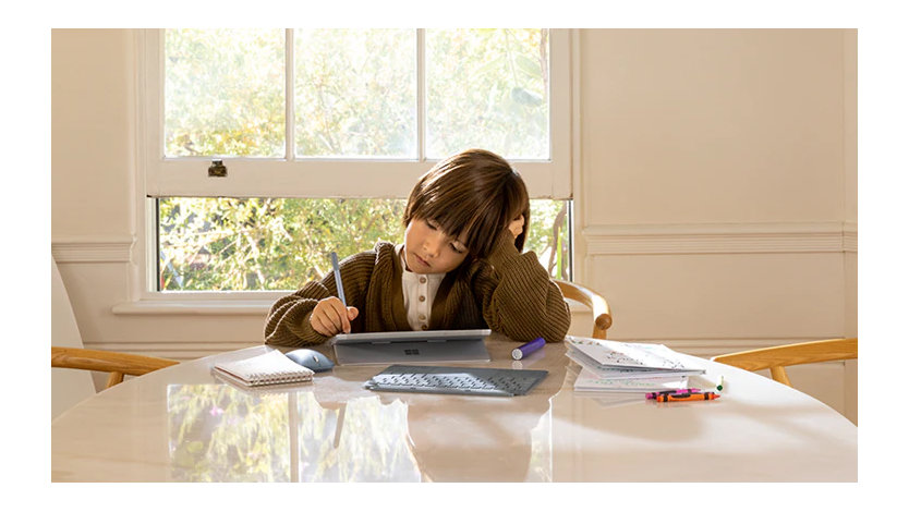 ペンで Surface ラップトップを使用する少年