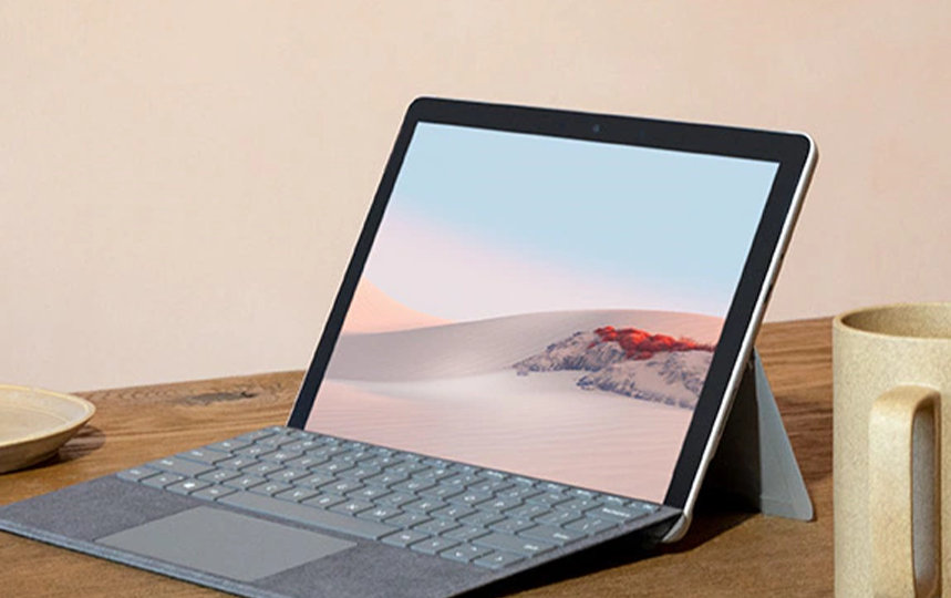 テーブルの上に置かれた Surface、カップと花