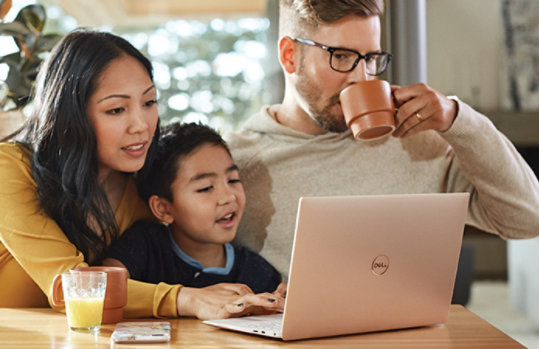 子どもとノート PC を操作する母親とy子で見ている父親