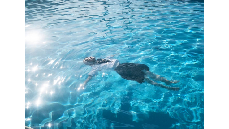 女の人が水の中で浮かび、泳いでいる様子