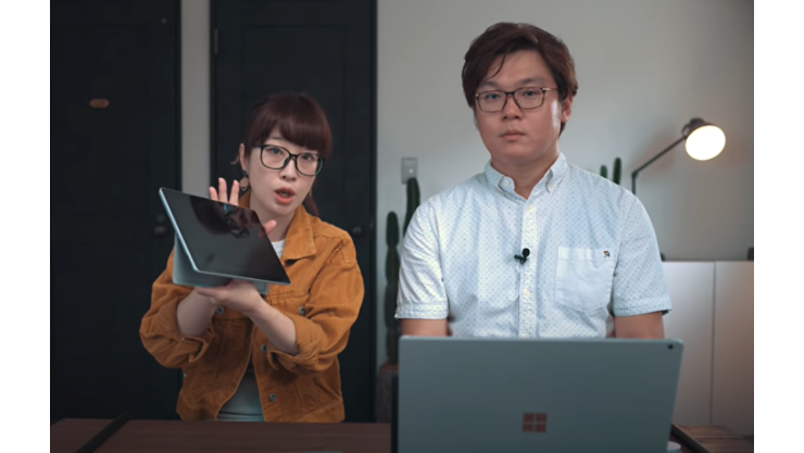 Surface Go 2 を持っている女性と Surface Book 3 の前に座っている男性