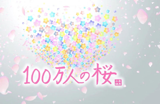 「100 万人の桜」テキストはピンク色で書かれており、ハート型のクラスターから花びらがはじけています。