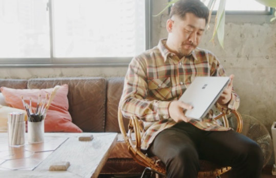 Surface Laptop Studioを持つイラストレーター アボット奥谷の