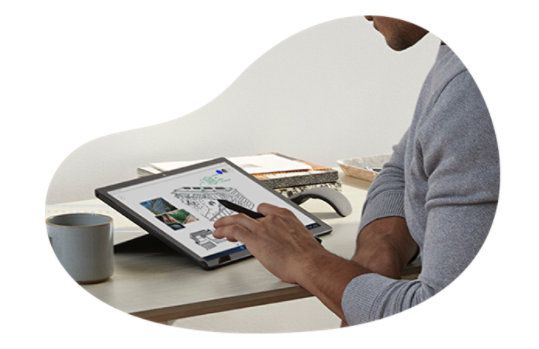 男性が机の上で Surface Pro 9 を使用している