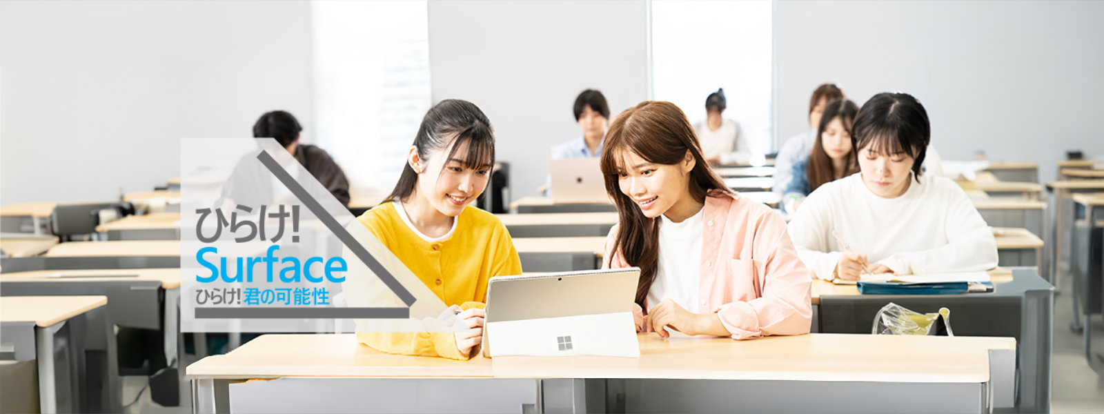 女性 2 人が Surface を開いて画面を見ている