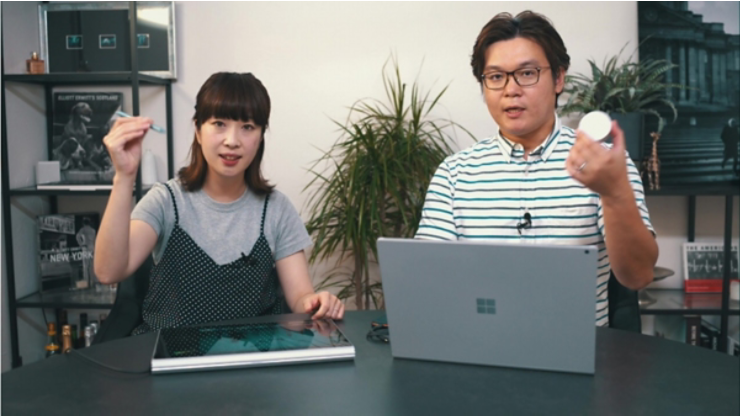 Surface Book 3 の前で Surface ペンと Surface Dial を持っている女性と男性