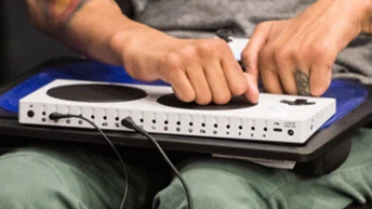 Ein Mann im Rollstuhl nutzt einen Xbox Adaptive Controller.