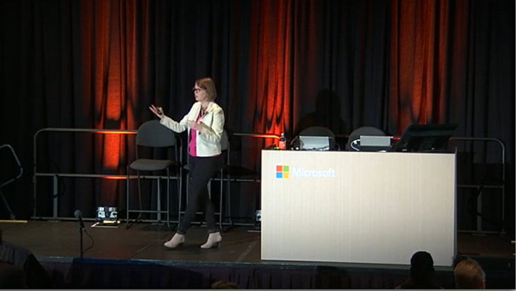 Eine Frau hält auf einer Bühne eine Rede.