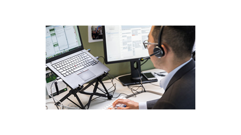 ヘッドセットを装着した男性が机の上で作業している