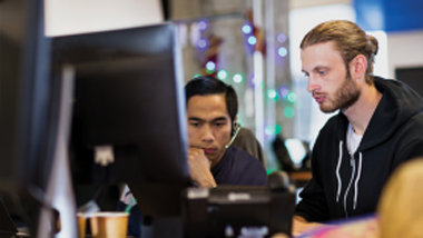 2 人の IT プロフェッショナルがオフィスで一緒に働いています