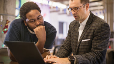  デジタル コンサルティング会社で共同作業する 2 人の IT プロフェッショナル。