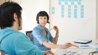  現代のオフィスで話している男性と女性の同僚