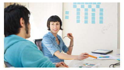  現代のオフィスで話している男性と女性の同僚