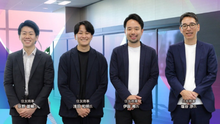 カラフルな背景の前で、4人の男性が立っており、それぞれの下に名前と会社名が書かれている。