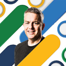 カラフルなストライプと円を背景にした笑顔の男性。