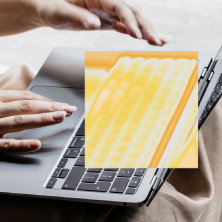 ノートパソコンのトラックパッドを操作する両手。