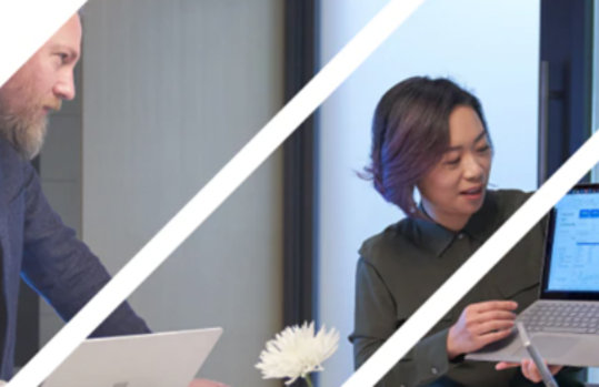 ノートパソコンを見て話す男女