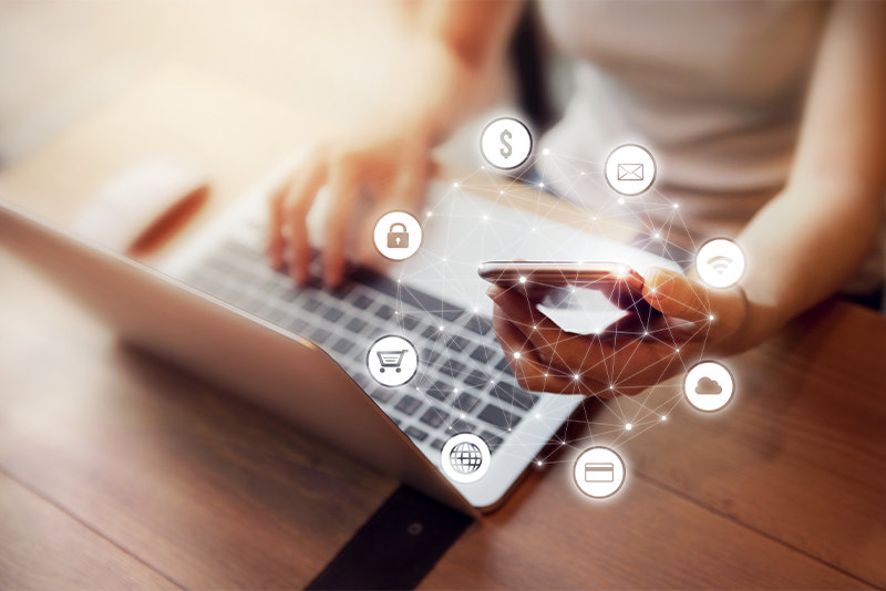 ノート PC とスマートフォンを操作する人物