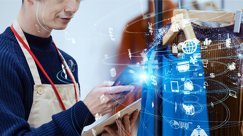 スキャナーで衣服をチェックする衣料品小売店の従業員