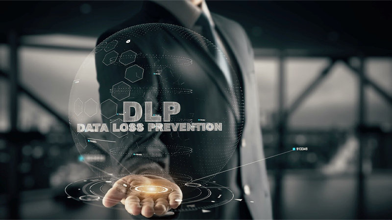 「DLP - DATA LOSS PREVENTION」というテキストが前景に書かれ、背景にビジネススーツを着た人物が描かれています「DLP - DATA LOSS PREVENTION」というテキストが前景に書かれ、背景にビジネススーツを着た人物が描かれています