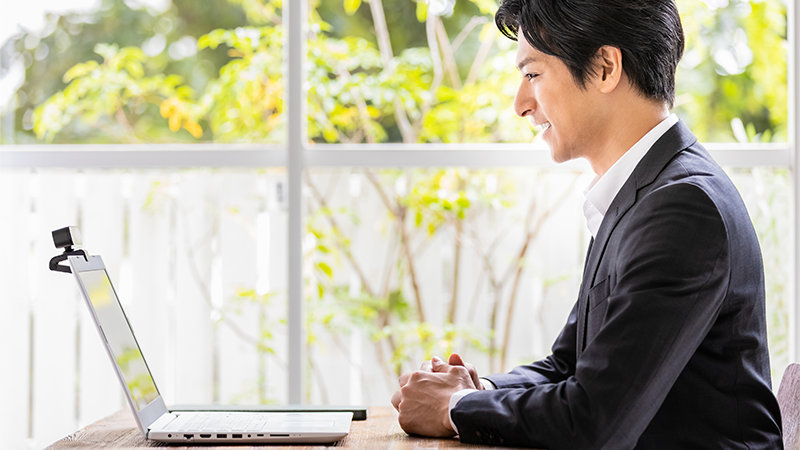 ノート PC に向かって話をするビジネス パーソン