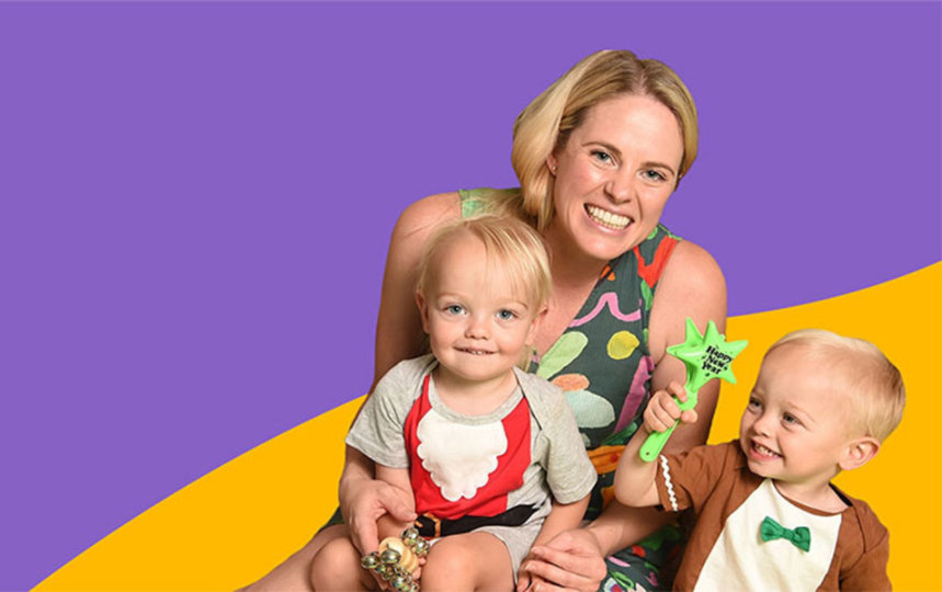 Kelly McKenzie with her two children on a purple and yellow background behind them.