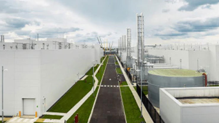 An illustation of a straight road passing through an industrial exterior side view including cooling exhaust towers