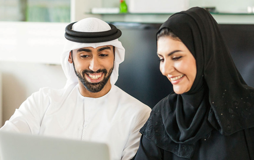 Young couple is using laptop at home to discuss business matters together