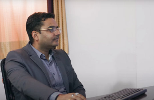 A slide featuring an image of government official using AI on his computer, representing AI integration in governance.