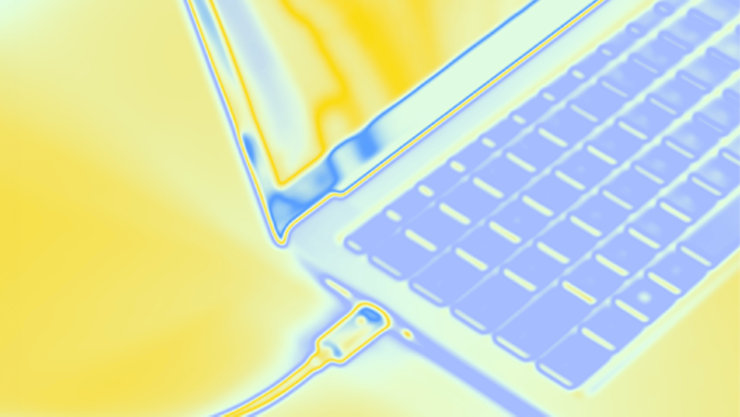 Nahaufnahme eines Laptops in Falschfarben. Ein Kabel ist in die Seite des Geräts eingesteckt, die Tastatur ist teilweise sichtbar.