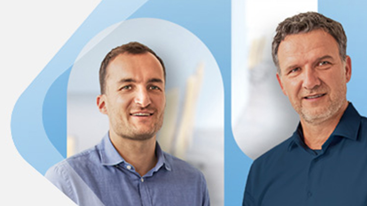 Zwei Personen blicken in die Kamera.