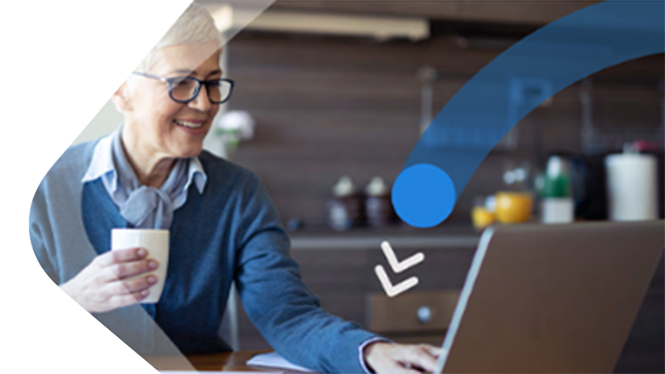 Eine Frau mit Tasse in der Hand sieht lächelnd auf einen Laptop.