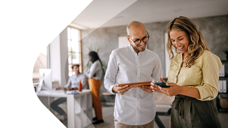 Ein Mann und eine Frau schauen gemeinsam lachend auf ein Smartphone.