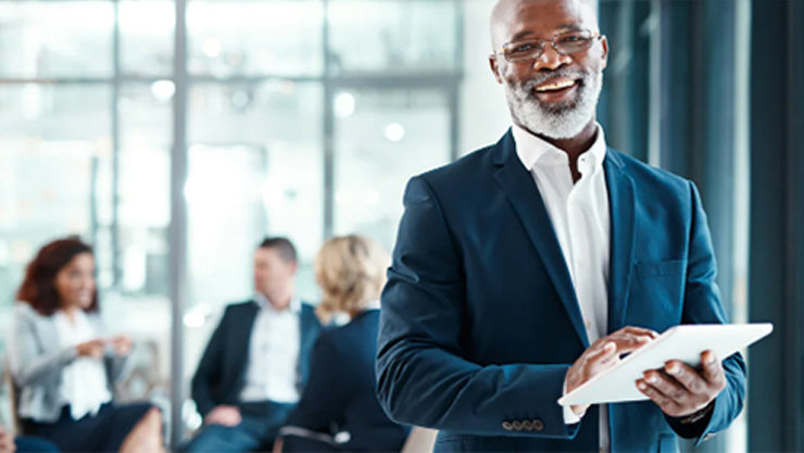 Ein Mann hält ein Tablet in der Hand.