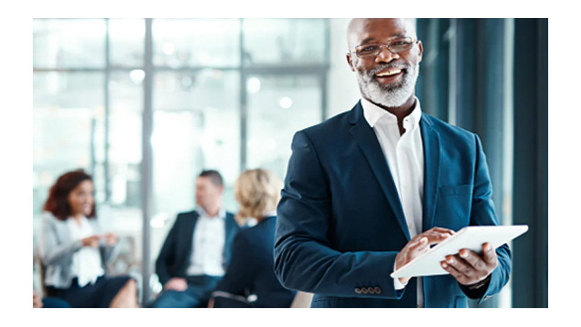 Ein Mann lächelt in die Kamera, er trägt einen blauen Anzug