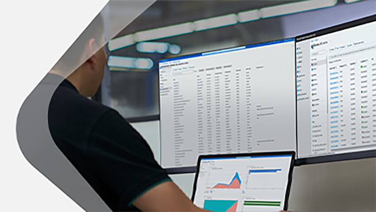 Eine männliche Person sitzt vor mehreren Monitoren.