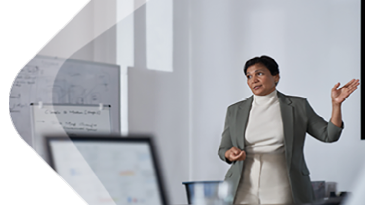 Eine Frau präsentiert sich in einem Konferenzraum mit einer weißen Wand dahinter