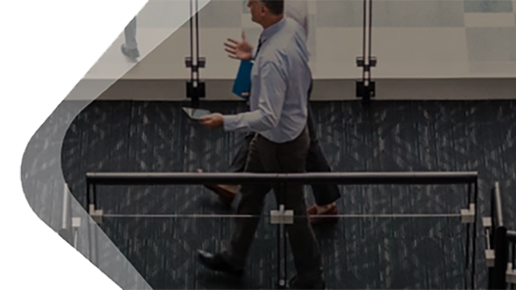 Ein Mann und eine Frau befinden sich in einem Office mit vielen Bildschirmen.