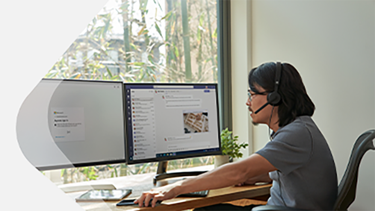 Ein Mann mit Brille sitzt vor zwei Bildschirmen.