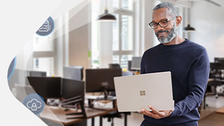 Ein Mann schaut lächelnd auf einen Bildschirm.