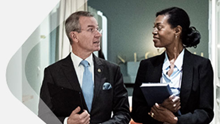 Ein Mann und eine Frau in Anzug und Kostüm schauen sich gegenseitig an.