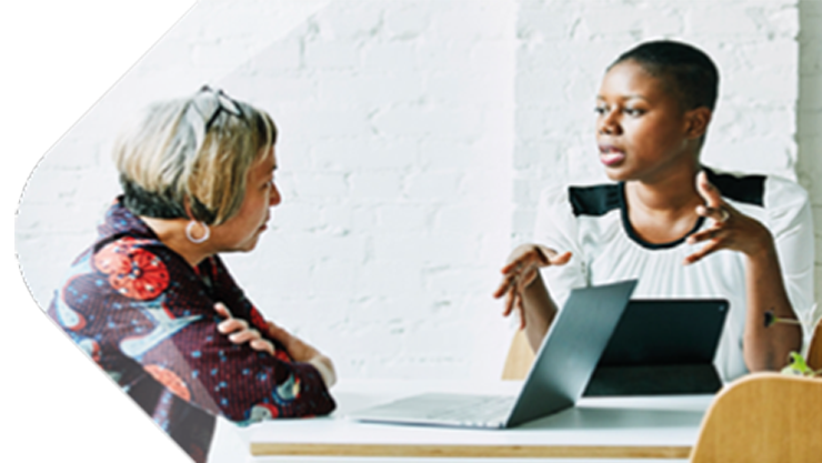 Zwei Frauen unterhalten sich am Arbeitsplatz