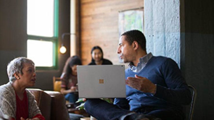 Mehrere Personen arbeiten zusammen an einem Laptop