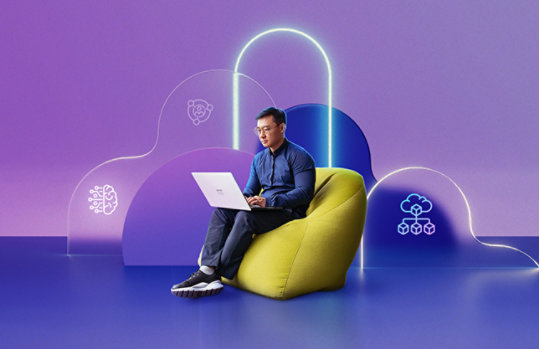 Ein Mann sitzt mit dem Laptop auf dem Schoß auf einen gelben Sitzsack. Der Hintergrund besteht auf animierten abstrakten Elementen.